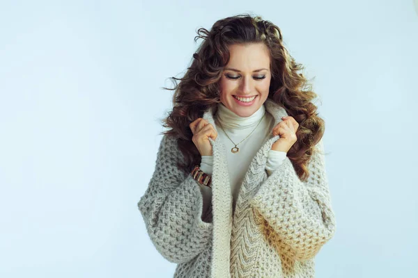 Glückliche junge Frau vor winterlichem hellblauen Hintergrund — Stockfoto