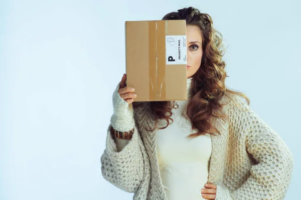 Modern female holding parcel in front of face — Stock Photo, Image