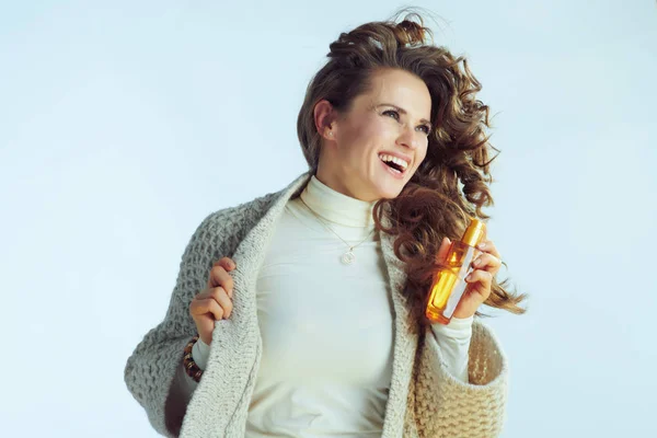 Feliz dona de casa moderna com produtos de cuidados com o cabelo saltando — Fotografia de Stock