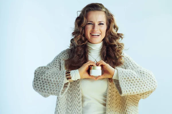 Hona som håller vintern ansiktskräm i hjärtformade händer — Stockfoto