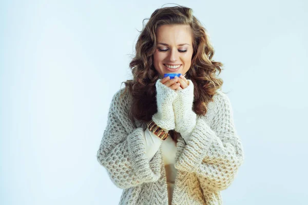 Glimlachende stijlvolle vrouw genieten winter gezichtscrème — Stockfoto