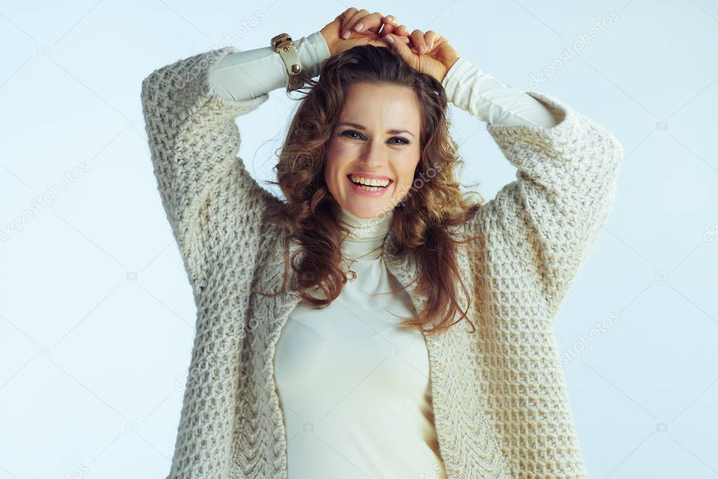 smiling stylish woman isolated on winter light blue background