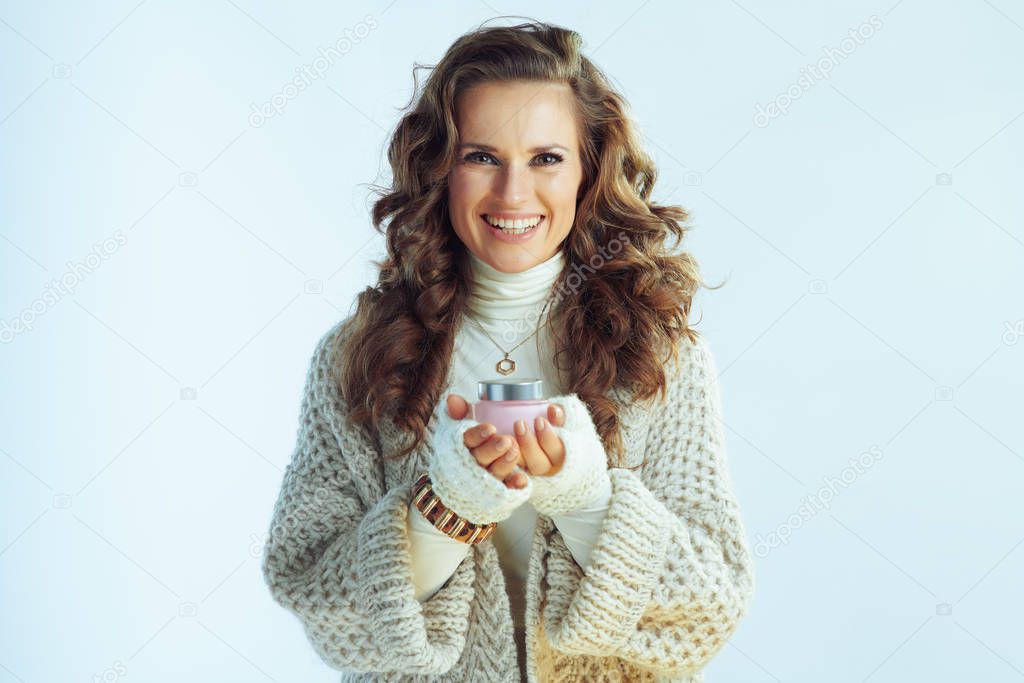 smiling modern woman showing winter skin care facial creme