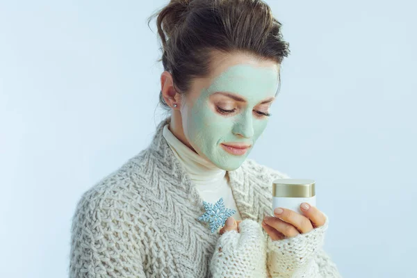 Hemmafru med grön ansiktsmask som håller burk och snöflinga — Stockfoto