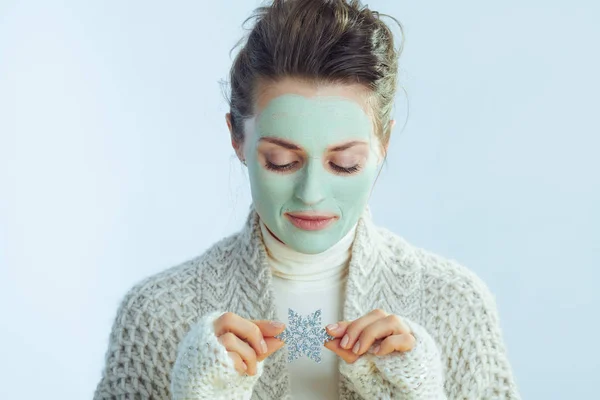 Modern female with green facial mask holding snowflake — Stock Photo, Image