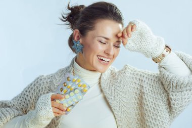 40 yaşında mutlu bir stil. Elinde bir paket hap tutan bir kadın.