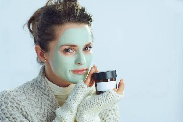 Elegant hona med grön ansiktsmask visar kosmetisk burk — Stockfoto