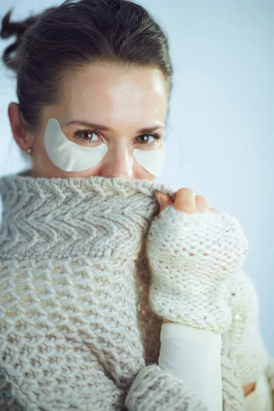 Женщина с косметическими повязками на глазу, прячущаяся за одеждой — стоковое фото