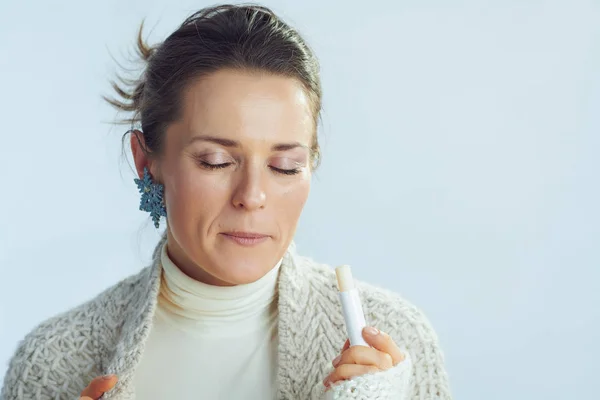 Stylish middle age housewife using lip balm as winter lip care — 스톡 사진