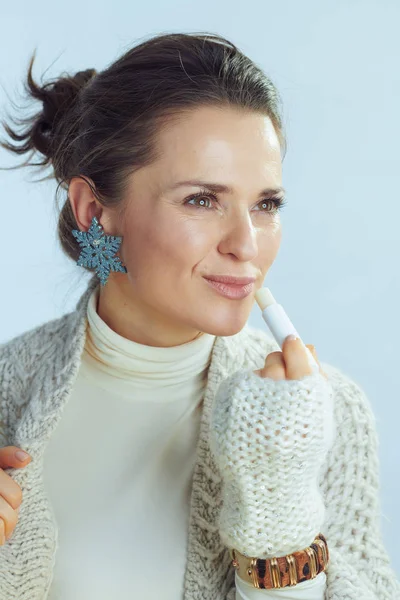 Modern middle age woman using lip balm as winter lip care — Stock Photo, Image