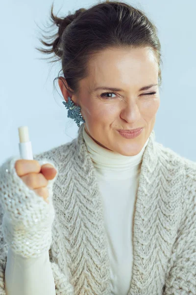 Happy stylish housewife showing lip balm as winter lip care — ストック写真