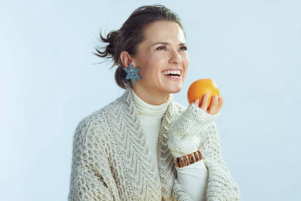 Feliz elegante fêmea olhando para o espaço cópia segurando laranja — Fotografia de Stock