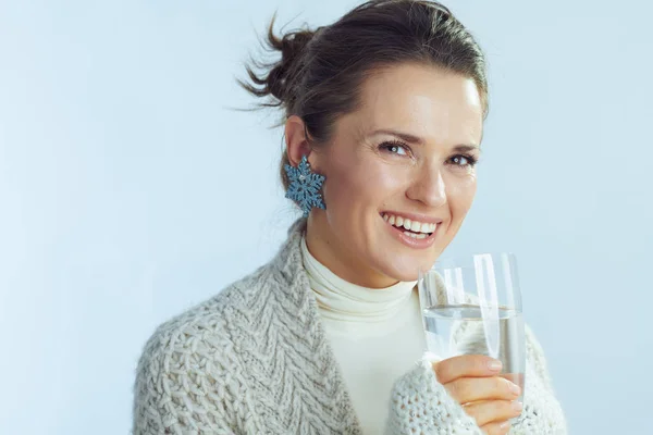 Hemmafru med glas vatten på vintern ljusblå bakgrund — Stockfoto