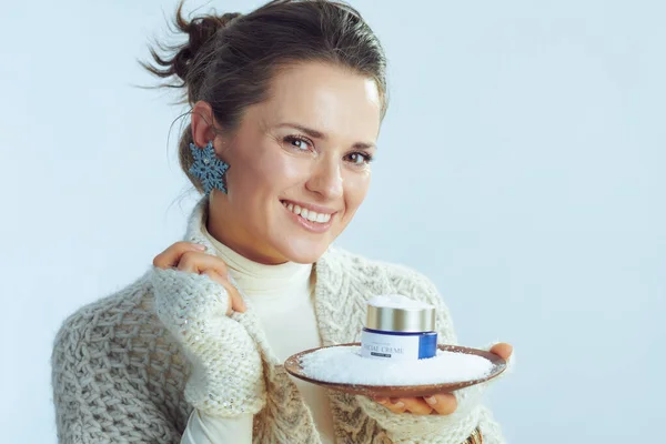 Щаслива стильна домогосподарка тримає тарілку з кремом серед снігу — стокове фото