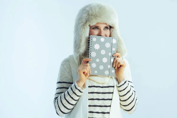 Trendy female while hiding behind notebook — Stock Photo, Image