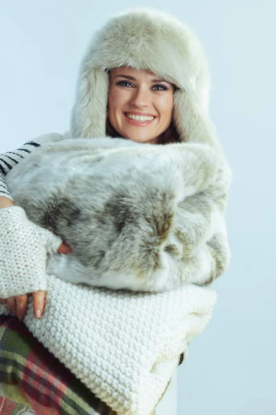 Усміхнена елегантна жінка тримає стек теплих ковдр — стокове фото