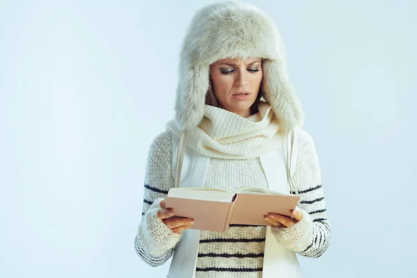 Female reading book isolated on winter light blue background — Stock Photo, Image