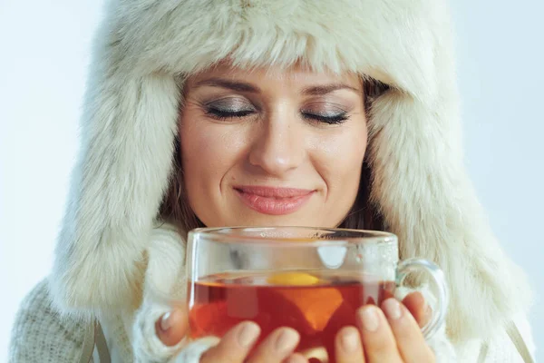 Mulher relaxada desfrutando de xícara de chá quente com limão e mel — Fotografia de Stock