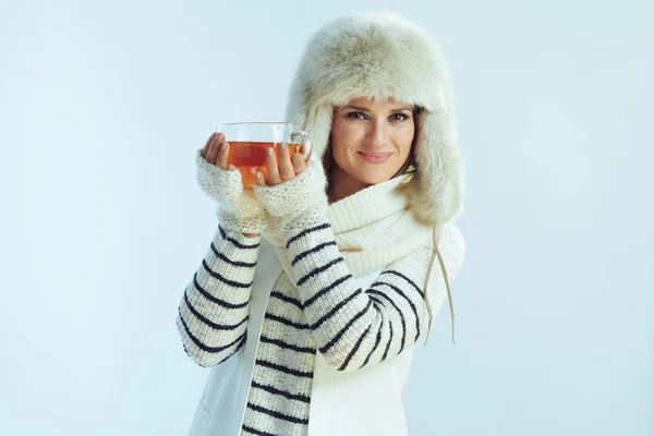 Mujer sonriente mostrando taza de té caliente con limón y miel — Foto de Stock