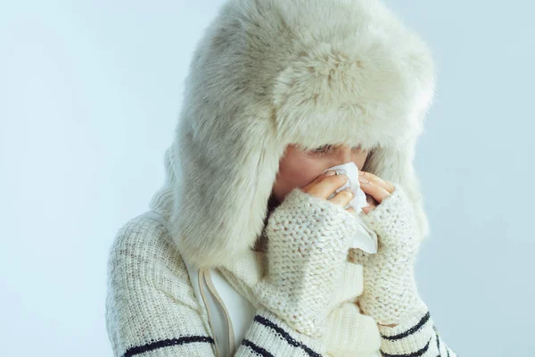 Woman wiping nose with napkin on winter light blue background — Stock Photo, Image