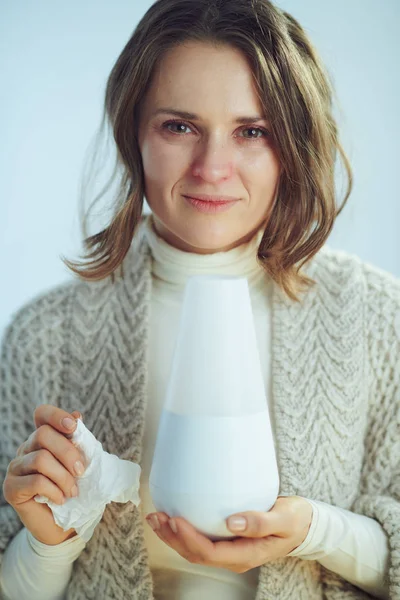 Źle elegancka kobieta w średnim wieku z serwetką trzymającą lampę zapachową — Zdjęcie stockowe