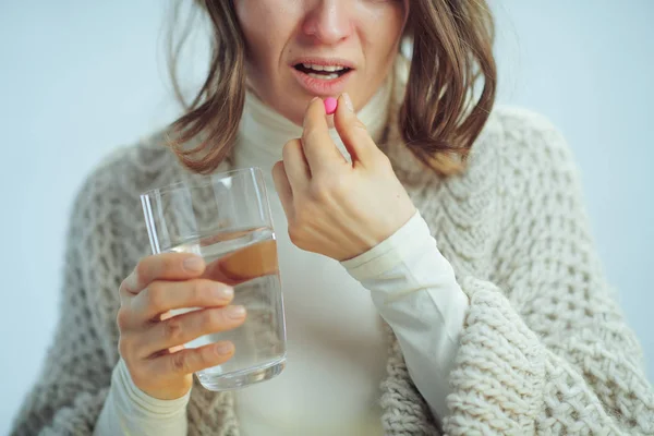 Primer plano de la mujer cansada con la taza de agua que come píldora —  Fotos de Stock