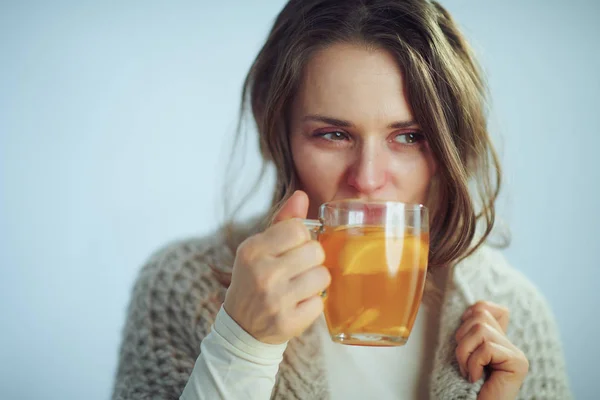 Dona de casa beber xícara de chá no inverno luz azul fundo — Fotografia de Stock