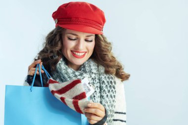 smiling female with blue shopping bag checking purchases clipart