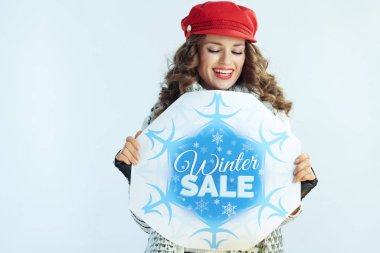 Mutlu moda 40 yaşındaki kadın kış indirimi afişine bakıyor.