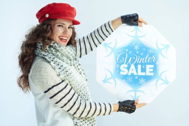 Gülümseyen genç kadın kış indirimi bayrağı gösteriyor