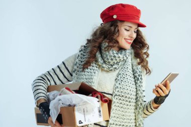 smiling trendy female holding opened parcel and app clipart