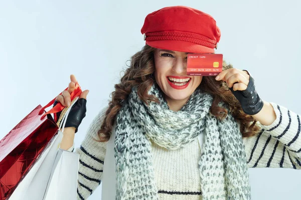 Glimlachende vrouw shopper geïsoleerd op winter licht blauwe achtergrond — Stockfoto