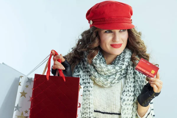 Düşünceli kadın alışverişçi kışın açık mavi arka planda izole edilmiş. — Stok fotoğraf