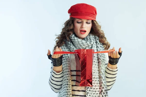 Mujer de moda sorprendida mirando dentro de la bolsa de compras roja — Foto de Stock