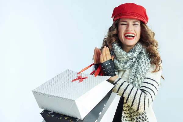 Mujer shopper aplaudiendo contra invierno luz azul fondo —  Fotos de Stock