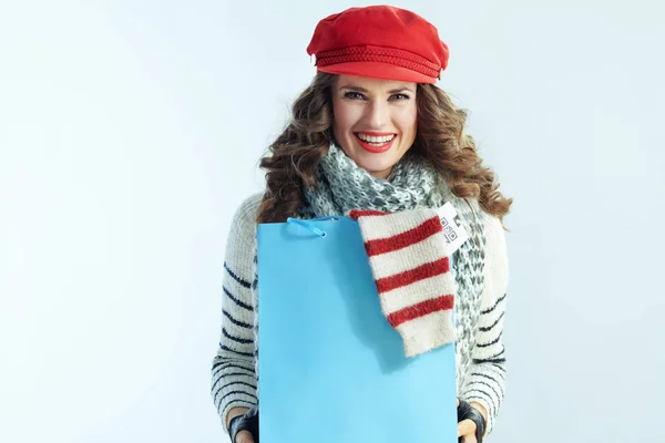 Femme souriante montrant sac à provisions bleu avec pull acheté — Photo