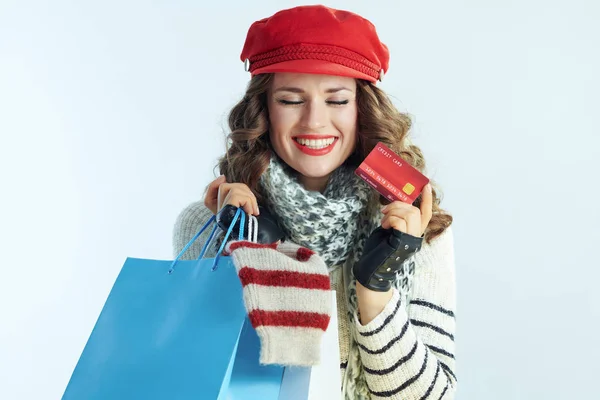 Female with shopping bags with sweaters showing credit card — Stock Photo, Image