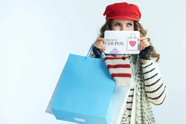 Θηλυκό με τσάντες για ψώνια με πουλόβερ που δείχνει εκπτωτικό κουπόνι — Φωτογραφία Αρχείου