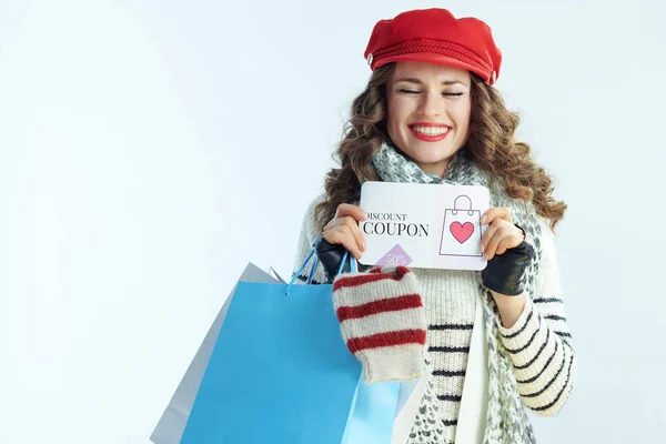 Mujer sonriente comprador con suéteres mostrando cupón de descuento —  Fotos de Stock