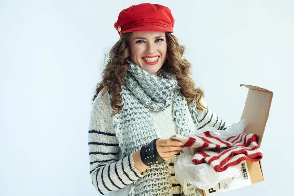 Happy elegant woman holding opened parcel with sweater — 스톡 사진