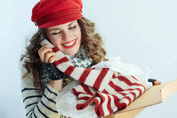 Mulher segurando pacote aberto e desfrutando de suéter entregue — Fotografia de Stock