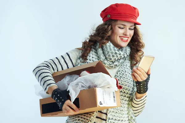 Happy elegant woman holding opened parcel and app — ストック写真
