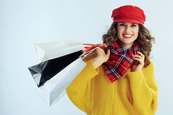 happy stylish woman shopper on winter light blue background