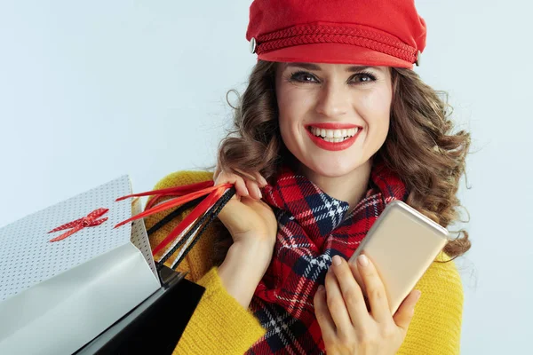 Женщина покупатель и смартфон на зимнем светло-голубом фоне — стоковое фото