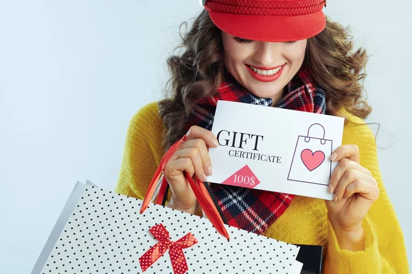 Sorridente donna moderna shopper mostrando buono regalo — Foto Stock