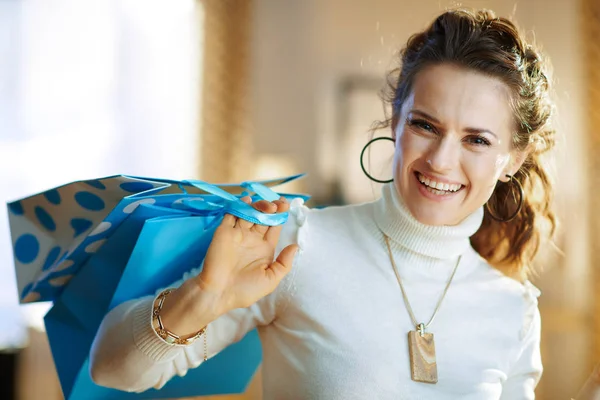 Gelukkig stijlvolle vrouw met blauwe boodschappentassen — Stockfoto