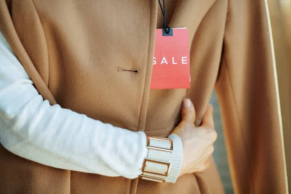 Крупним Планом Жінку Білому Светрі Тримає Бежеве Пальто Цінником Продаж — стокове фото