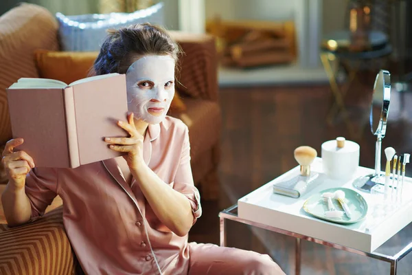 Stijlvolle Middelbare Leeftijd Huisvrouw Pyjama Met Witte Laken Gezichtsmasker Zoek — Stockfoto