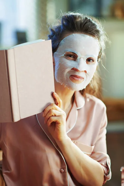 Elegancka Gospodyni Domowa Piżamie Białym Prześcieradłem Maska Twarz Patrząc Książki — Zdjęcie stockowe