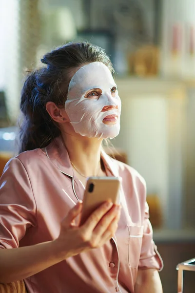 Dona Casa Moderna Pensativa Pijama Com Máscara Facial Folha Branca — Fotografia de Stock